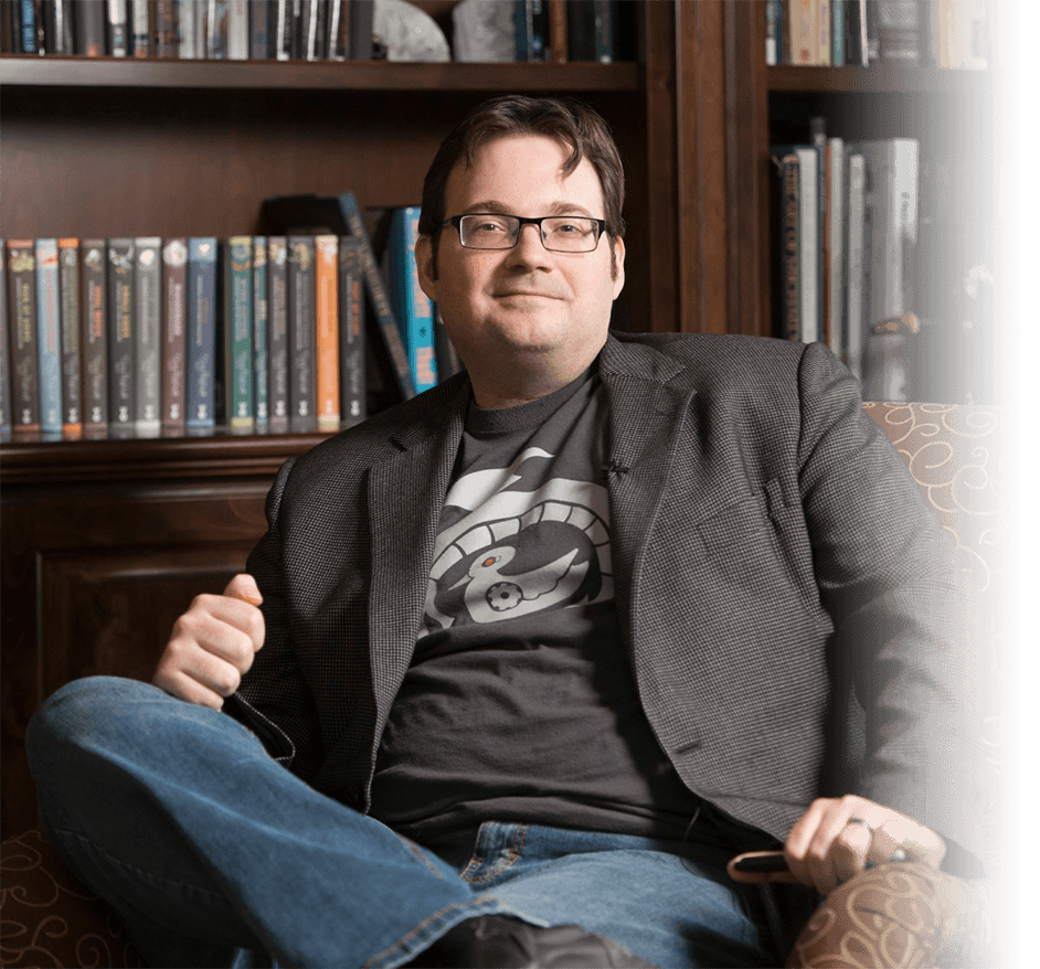 Author Brandon Sanderson sitting and smiling at you