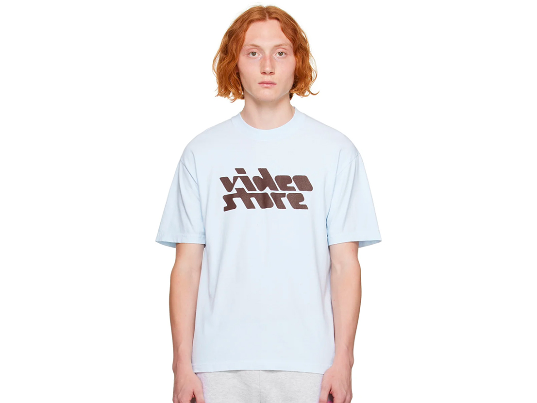 white t-shirt that says VIDEO STORE in brown.