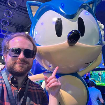 A fan posing with a Sonic the Hedgehog statue