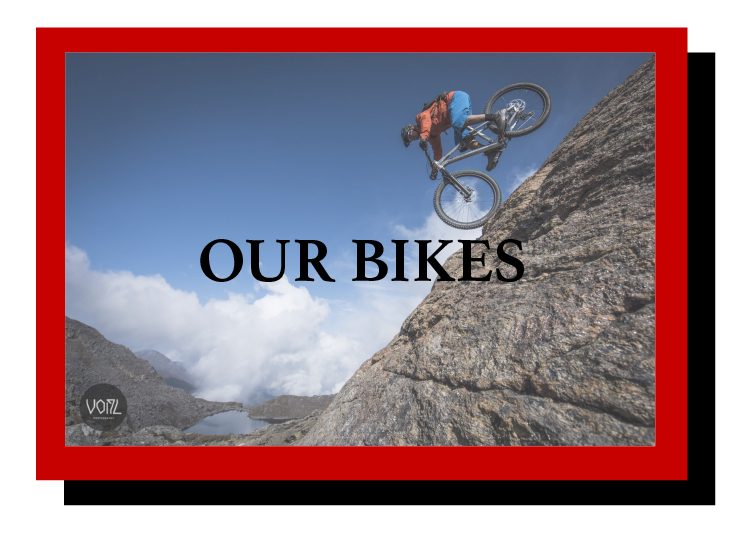 a person riding down a steep rock face with the words 'Our Bikes'