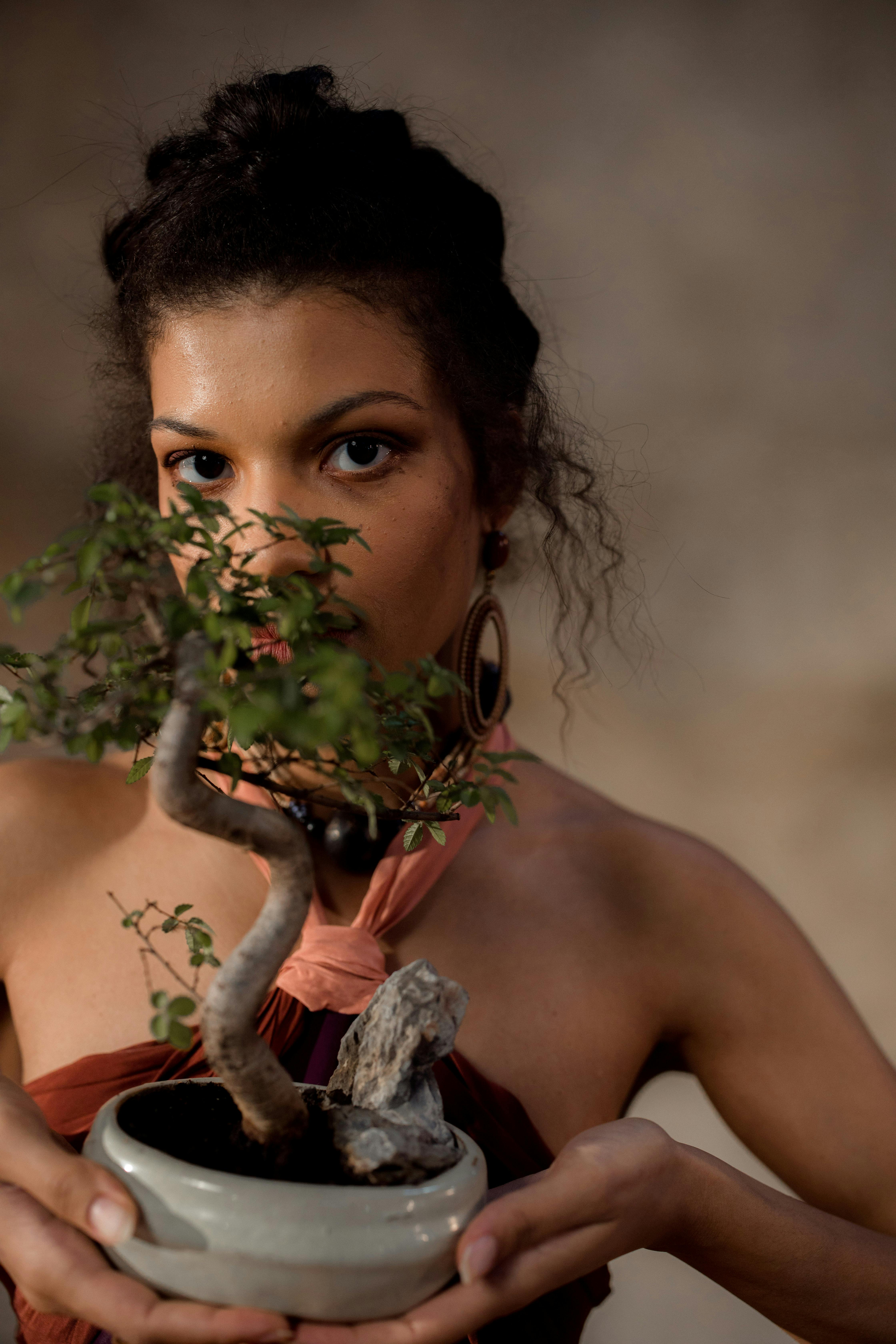 a woman holding a bonsai