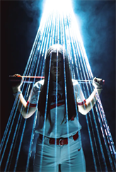 A high school softball player in a dark room, holding her baseball bat across her shoulders, with white lasers pointing down at her, going around her in a cone shape.