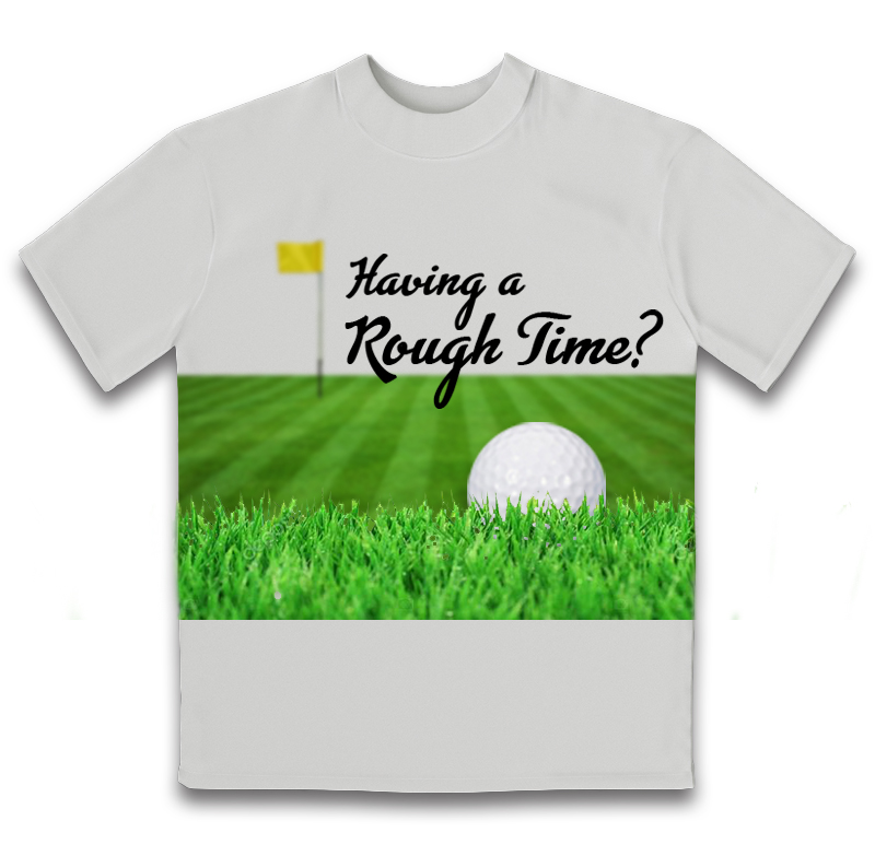 A white t-shirt that has an image of a golf ball stuck in tall grass. There is a yellow flag in the distance. Above this image is text that says 'Having a rough time?'