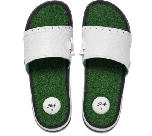 A pair of funny flip-flop style shoes. The soles of the shoes are covered in fake grass. on the heel part of each sole is a white rubber circle that looks like a golf ball. The thick white band that covers the top of the foot has holes in it for holding golf tees.